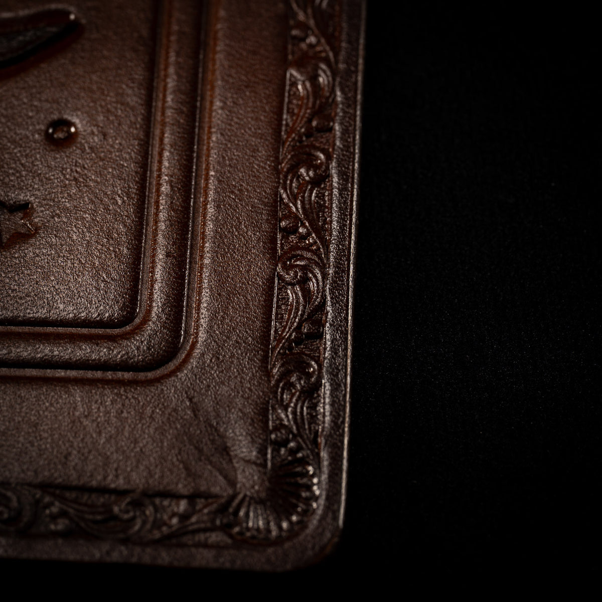 Corner of The Astro leather tarot mat showing the decorative border and finished edge