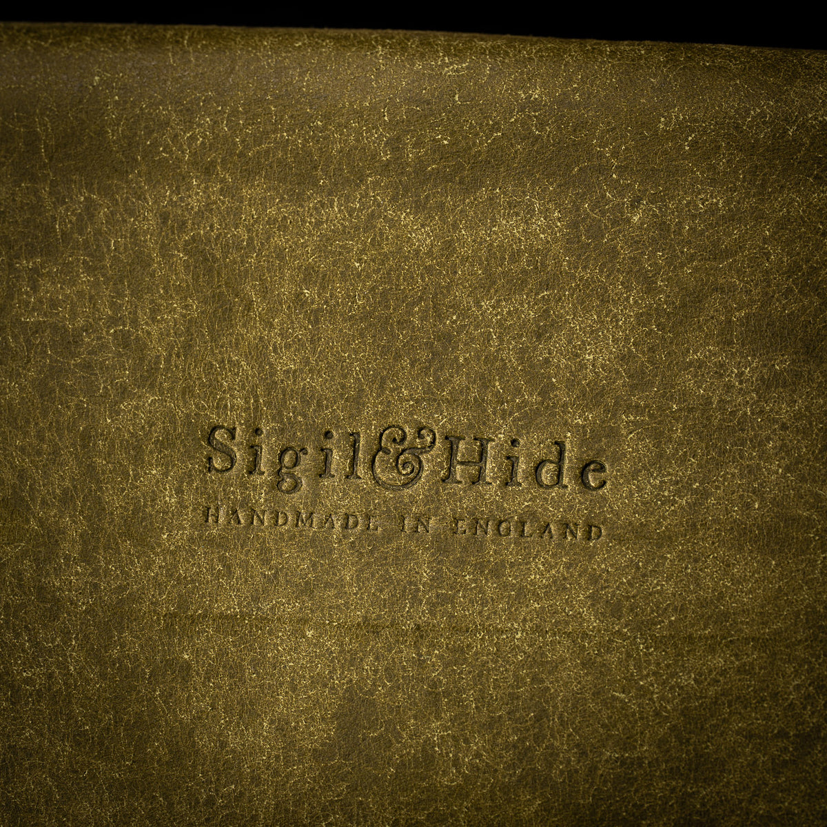 Close up of the Sigil and Hide maker's mark, Handmade in England, embossed into olive Pueblo leather