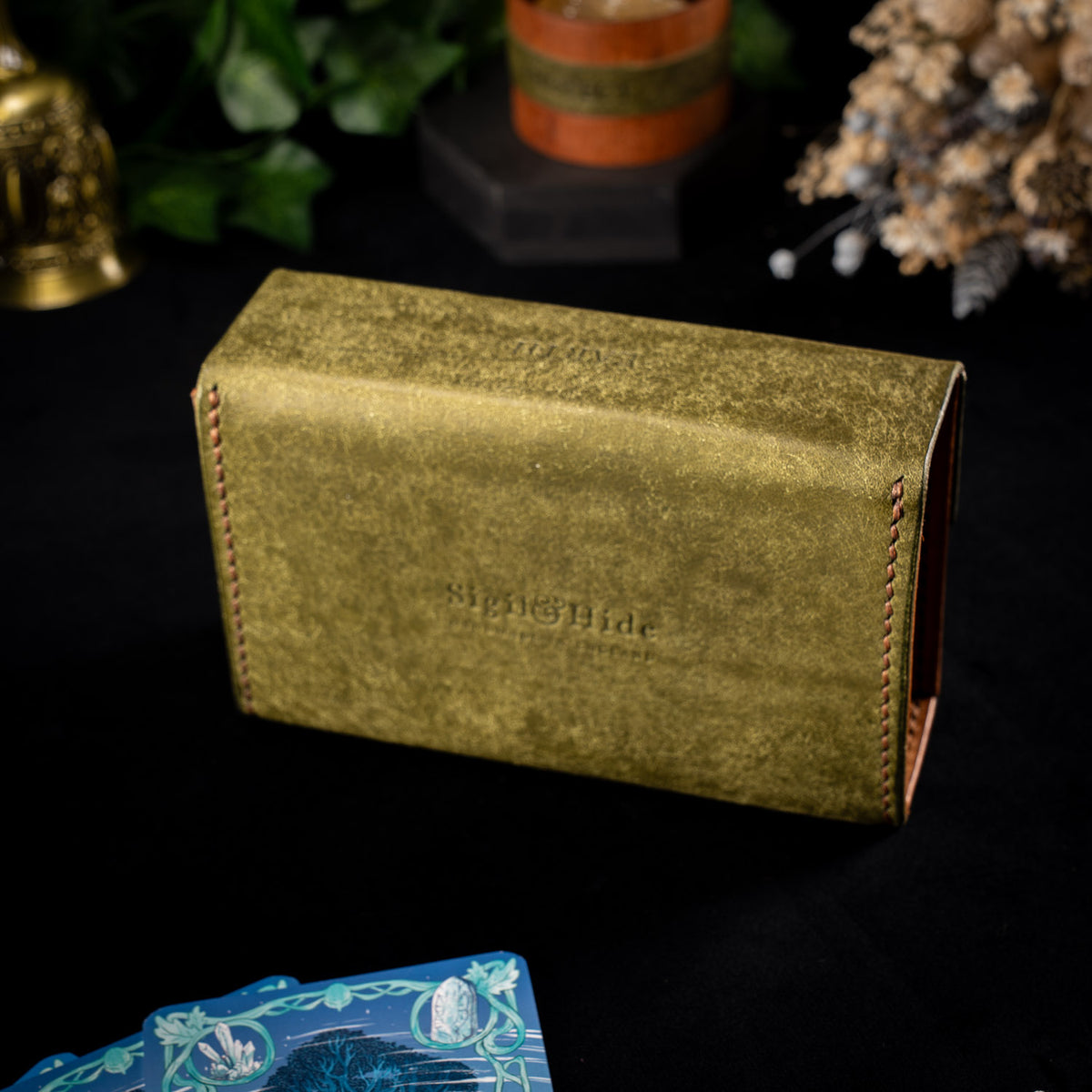 Back of the olive Earth Oracle case showing the Sigil and Hide maker's mark pressed into the leather