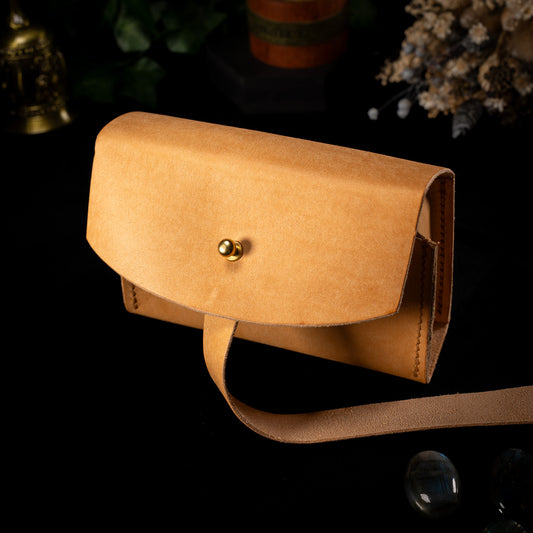 The Shroud deck case in natural Bone leather, the Air colourway, with a brass collar button and the wrap strap unfastened